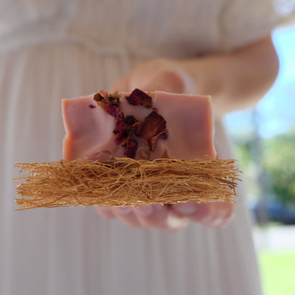 Natural pink tallow soap on a eco coconut soap rest