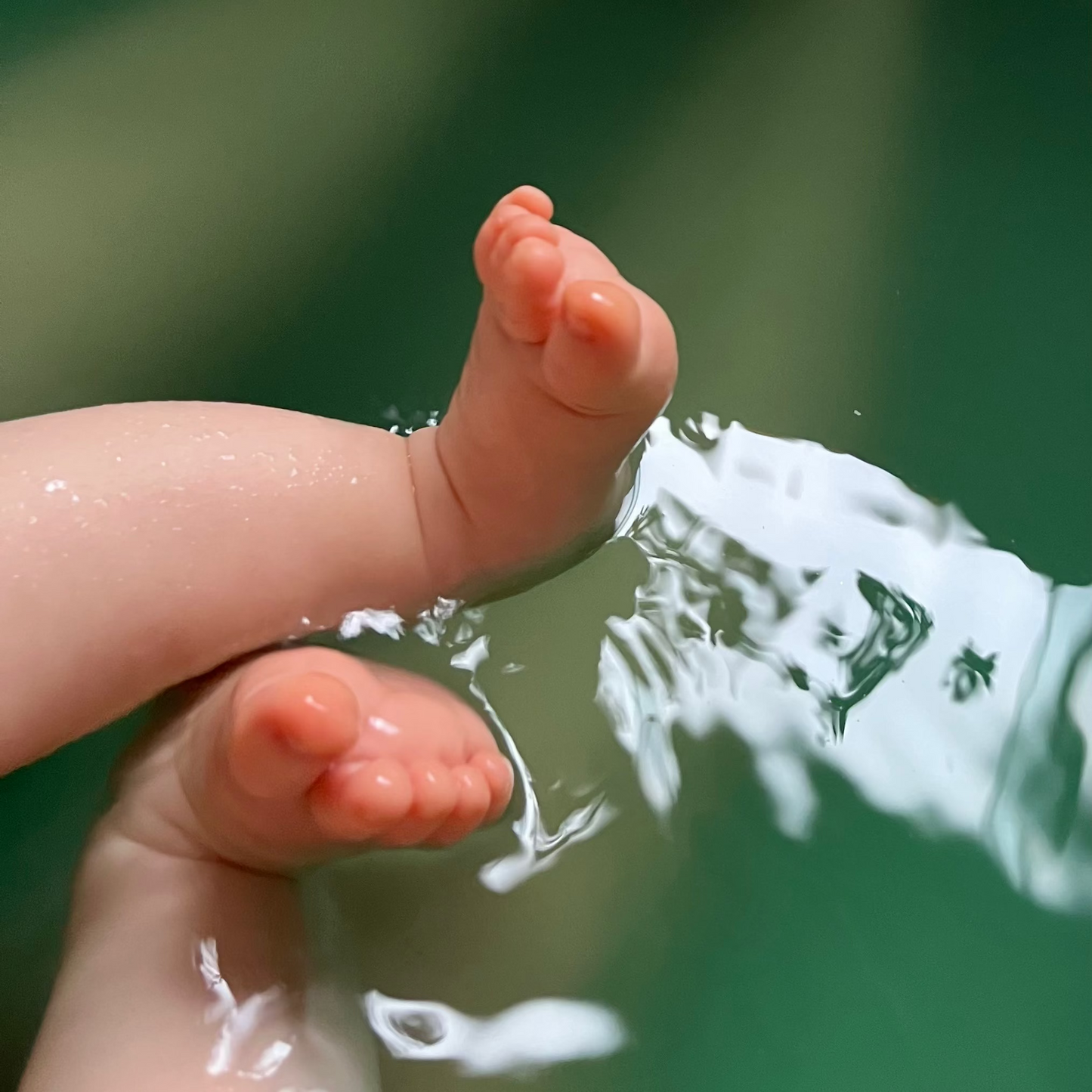 Close-up of a child's feet in herbal magnesium bath water, against a blurred natural background.